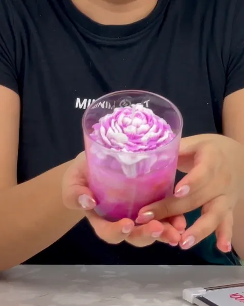 La instructora con una vela de flor en vaso