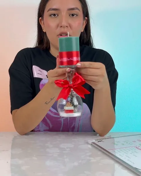 La instructora con una vela navideña con lazo rojo